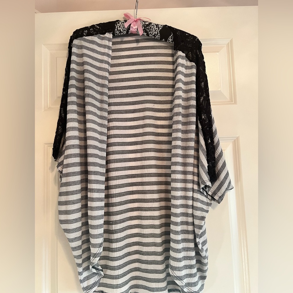 Light cardigan with black lack going down the sleeves
